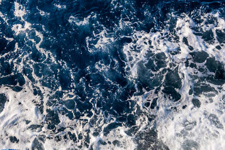 Top down aerial view of sea water surface. White foam waves texture as natural background.の写真素材