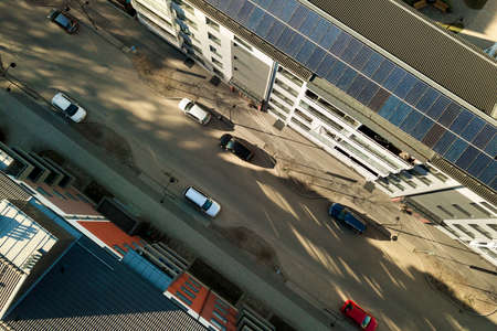 Aerial view of solar photovoltaic panels on a roof top of residential building block for producing...