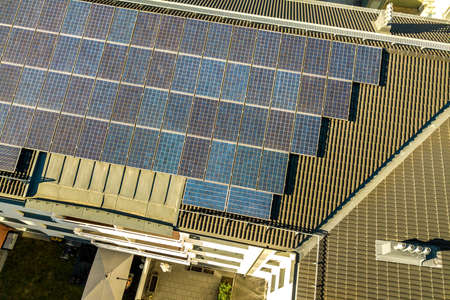 Aerial view of solar photovoltaic panels on a roof top of residential building block for producing...