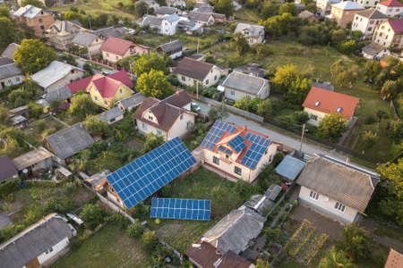 Aerial top view of new modern residential house cottage with blue shiny solar photo voltaic panels...
