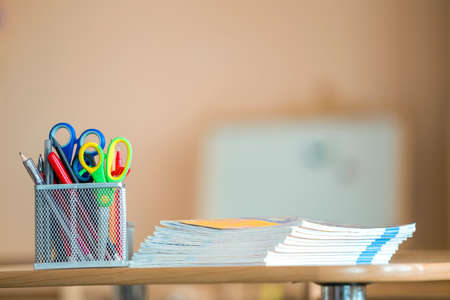 Stack of notebooks and stationery arrangement in classroom or office on copy space background