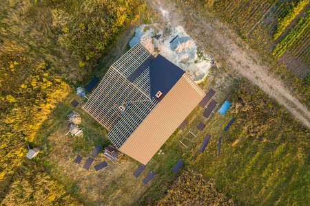 Aerial view of unfinished house with wooden roof structure covered with metal tile sheets under construction.の写真素材
