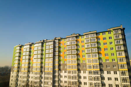 Aerial view of a tall residential apartment building with many windows and balconies.の写真素材