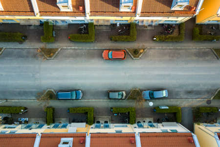Aerial view of residential houses with red roofs and streets with parked cars in rural town area. Quiet suburbs of a modern european city.の写真素材