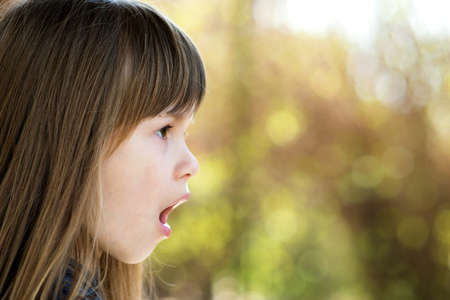 Portrait of surprised child girl outdoors in summer. Shocked female kid on a warm day outside.