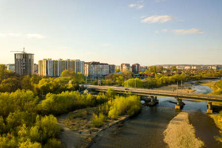 Aerial view of Ivano-Frankivsk city, Ukraine with Bystrytsia river and tall residential buildings under construction in distance.の写真素材