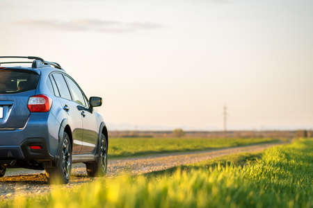 Landscape with blue off road car on gravel road. Traveling by auto, adventure in wildlife,...