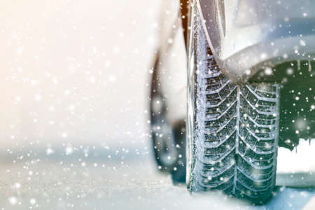 Close-up of car wheels rubber tires in deep winter snow. Transportation and safety concept.の写真素材