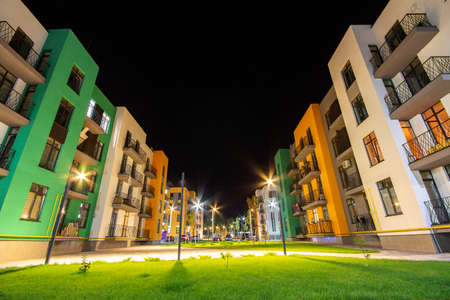 Yard between residential apartment buildings with green grass lawns and modern flat housing. Real...
