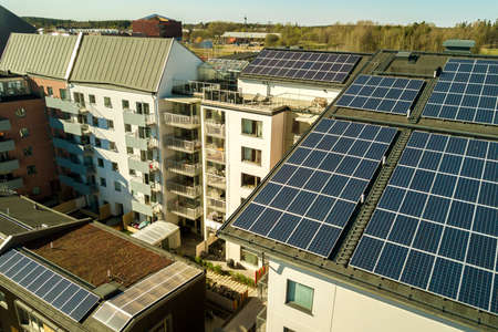 Aerial view of solar photovoltaic panels on a roof top of residential building block for producing clean electric energy. Autonomous housing concept.のeditorial素材