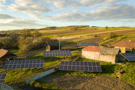Aerial top down view of solar panels in green rural village yard.