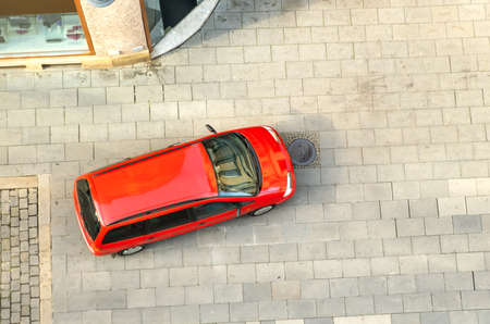 Top view of a car driving on a city street.