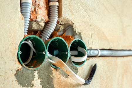 New electrical wiring installation, plastic boxes and electrical cables for future outlet sockets on...