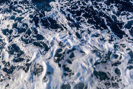 Top down aerial view of sea water surface. White foam waves texture as natural background.の写真素材