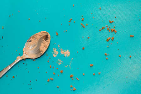 Close up of spoon with chocolate cream on blue copy space background. Culinary, baking and delicious...