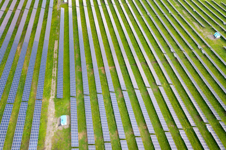 Aerial view of solar power plant on green field. Electric panels for producing clean ecologic...