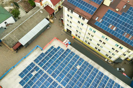 Aerial view of solar power plant with blue photovoltaic panels mounted of industrial building roof.のeditorial素材