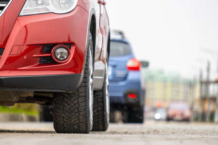 Closeup of parked car on a city street side with new winter rubber tires.の写真素材
