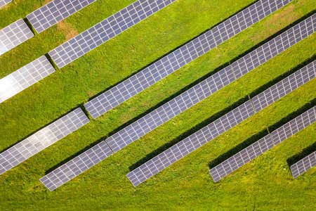 Aerial view of solar power plant on green field. Electric panels for producing clean ecologic energy.の写真素材