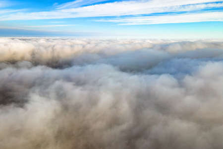 Aerial view from above of white puffy clouds in bright sunny day.の写真素材