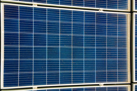 Closeup of surface of blue photovoltaic solar panels mounted on building roof for producing clean ecological electricity. Production of renewable energy concept.の写真素材