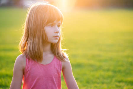 Portrait of young happy child girl relaxing outdoors on warm summer evening.の写真素材