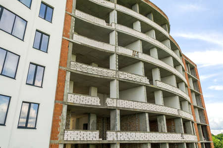 Many windows on new apartment building facade under construction.