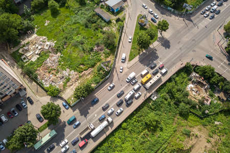 Top down aerial view of busy street intersection with moving cars traffic.