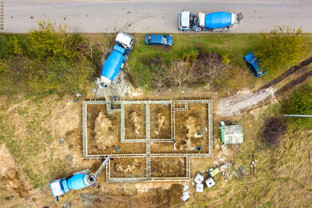 Top down aerial view of construction works of new house concrete foundation in rural residential...