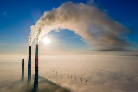 Aerial view of coal power plant high pipes with black smoke moving up polluting atmosphere at sunset.の写真素材
