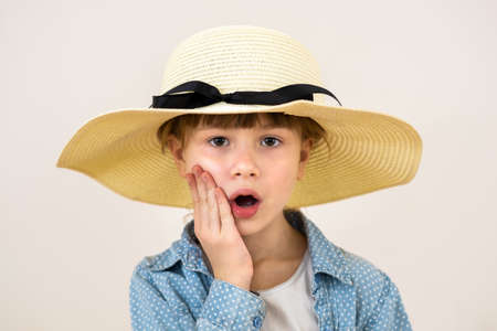 Close up portrait of cute little girl in beige hat with surprise emotion.