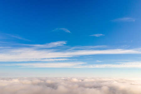 Aerial view from above of white puffy clouds in bright sunny day.の写真素材
