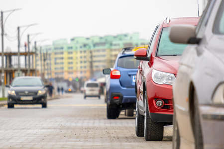 Cars parked in a row on a city street side.