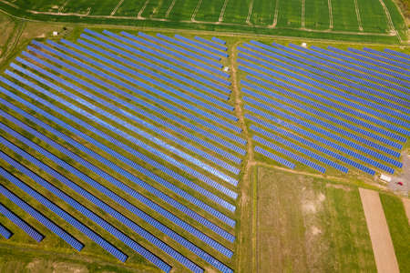 Aerial view of big sustainable electric power plant with many rows of solar photovoltaic panels for...