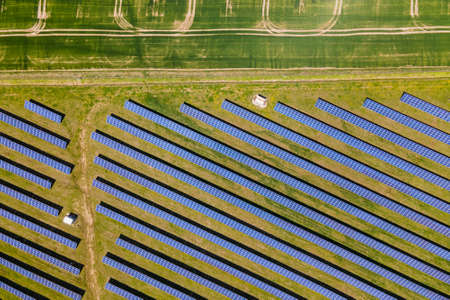 Aerial view of big sustainable electric power plant with many rows of solar photovoltaic panels for...