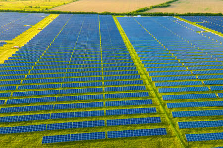 Aerial view of large sustainable electrical power plant with many rows of solar photovoltaic panels for producing clean ecological electric energy. Renewable electricity with zero emission concept.の写真素材