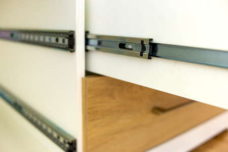 Close up of installation of wooden drawer in contemporary cupboard cabinet.の写真素材