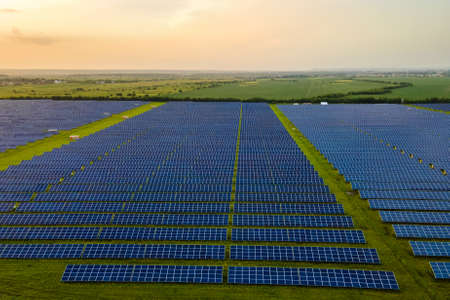 Aerial view of large sustainable electrical power plant with many rows of solar photovoltaic panels...