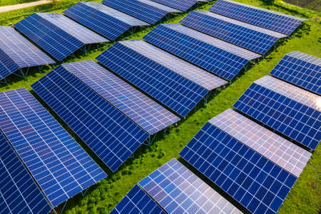 Aerial view of large sustainable electrical power plant with rows of solar photovoltaic panels for...