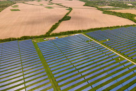 Aerial view of big sustainable electric power plant with many rows of solar photovoltaic panels for...
