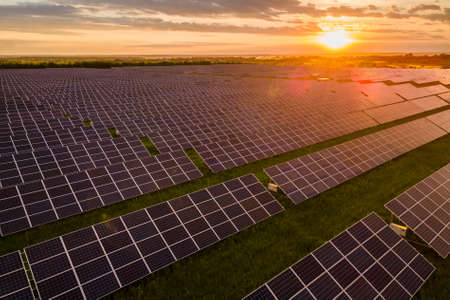 Aerial view of large sustainable electrical power plant with many rows of solar photovoltaic panels...