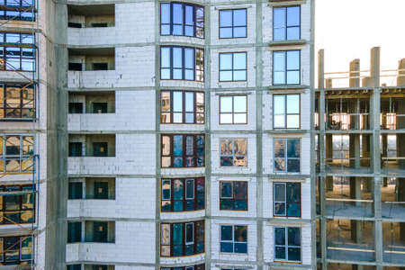 Aerial view of high residential apartment building under construction. Real estate development.
