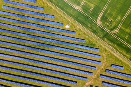 Aerial view of big sustainable electric power plant with many rows of solar photovoltaic panels for...