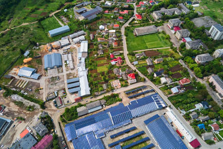 Aerial view of blue photovoltaic solar panels mounted on industrial building roof for producing green ecological electricity. Production of sustainable energy concept.の写真素材