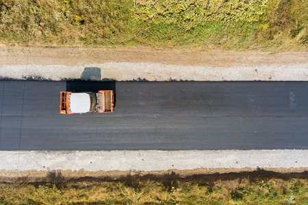 Aerial view of new road construction with steam roller machine at work.の写真素材
