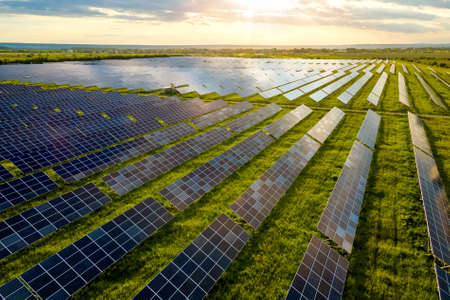 Aerial view of large sustainable electrical power plant with many rows of solar photovoltaic panels for producing clean ecological electric energy. Renewable electricity with zero emission concept.の写真素材