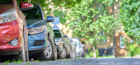 City traffic with cars parked in line on street side.の写真素材
