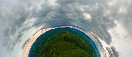 Little planet with dark mountain hills covered with green mixed pine and lush forest.