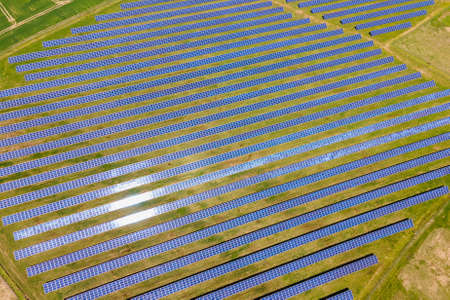 Aerial view of big sustainable electric power plant with many rows of solar photovoltaic panels for producing clean ecological electrical energy. Renewable electricity with zero emission concept.の写真素材