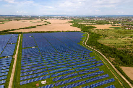 Aerial view of big sustainable electric power plant with many rows of solar photovoltaic panels for producing clean ecological electrical energy. Renewable electricity with zero emission concept.の写真素材
